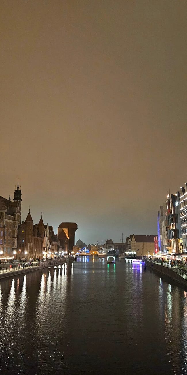 Motława w gdańsku nocą, z oświetlonymi nabrzeżami i odbiciami w wodzie