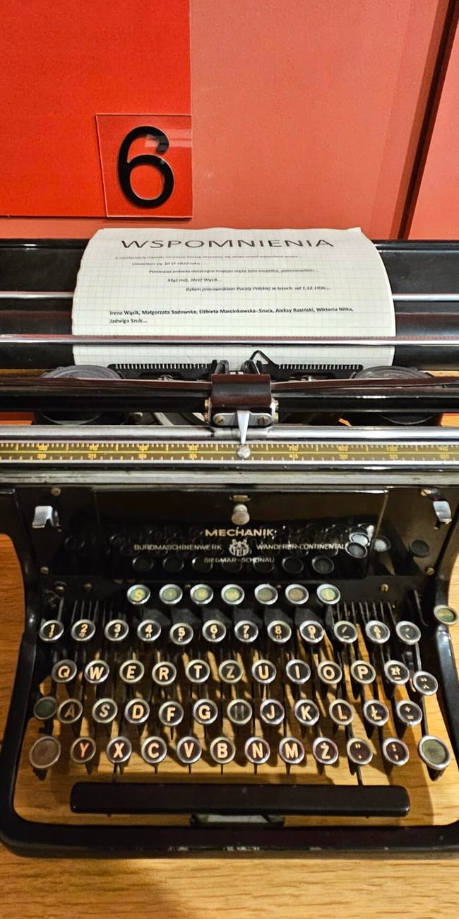 Maszyna do pisania w muzeum poczty polskiej w gdańsku, z kartką „wspomnienia” i numerem 6.