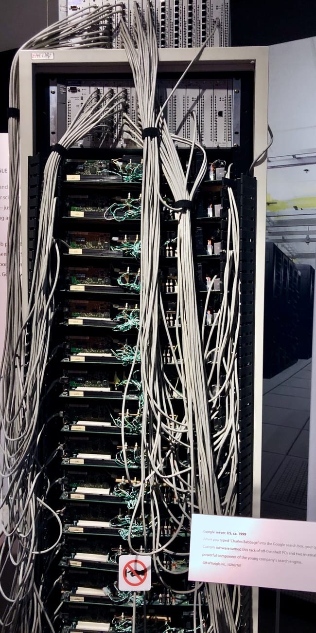 Komputerowy serwer google w computer history museum w mountain view, z wieloma kablami i opisową tabliczką.