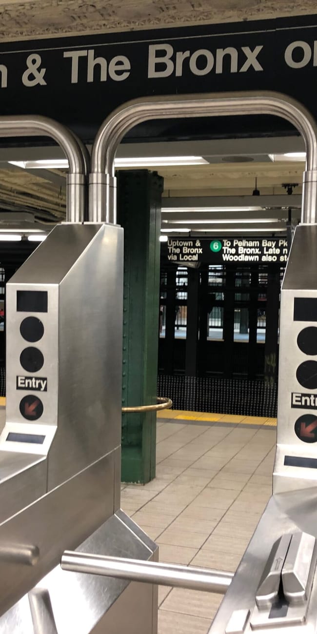 Bramki wejściowe na stacji metra 6 w nowym jorku z napisem uptown & the bronx only.