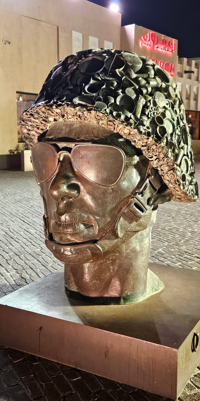 Rzeźba głowy w hełmie i okularach przeciwsłonecznych w katara cultural village w dosze, katar.