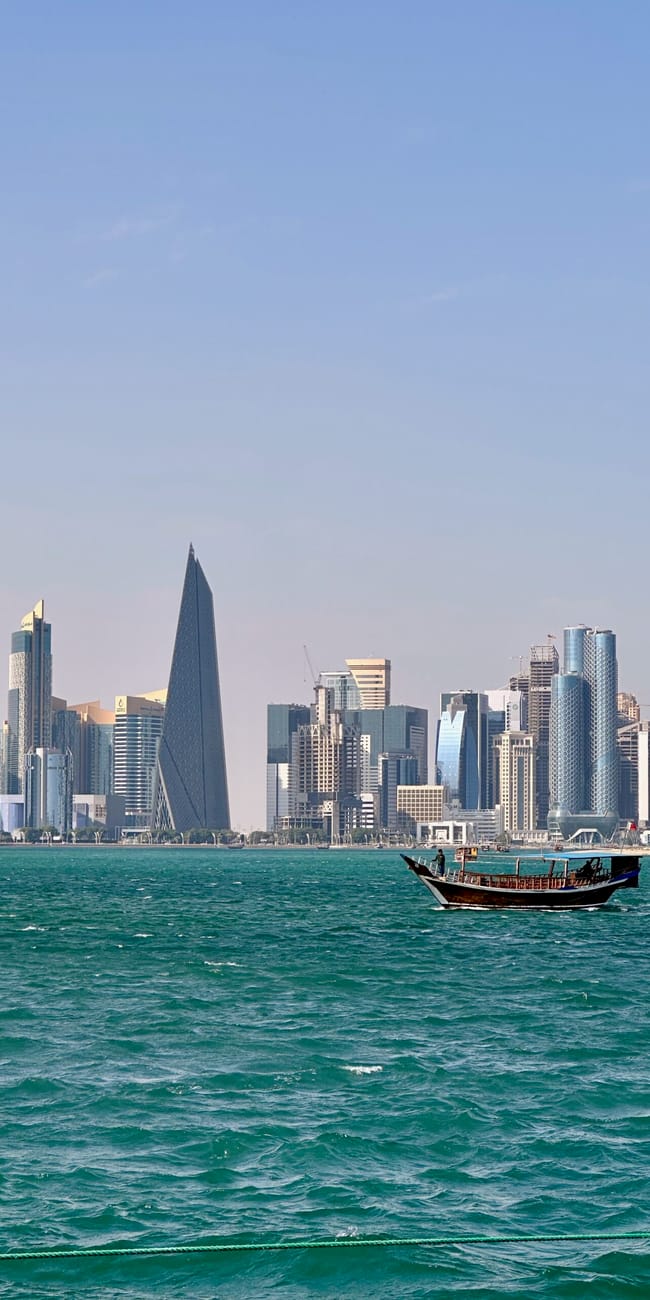 Panorama doha w katarze z tradycyjną łodzią na wodzie i linią wieżowców w tle