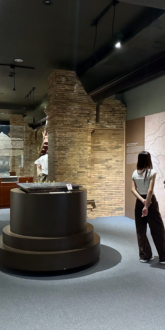 Wystawa w chiang mai city arts z modelami ruin i mapą na ścianie