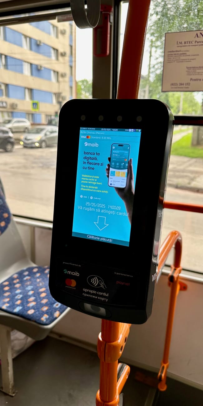 Chisinau public transport ticket validator screen inside a bus with a payment card on display