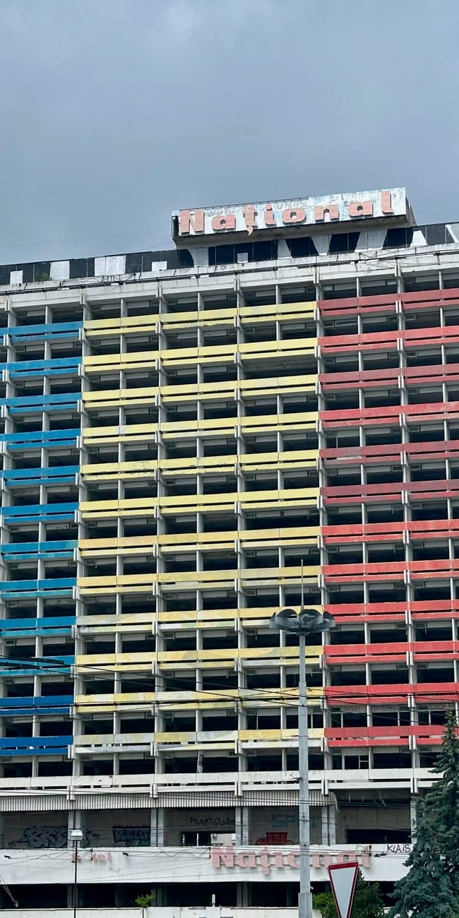 Moldova, chisinau places in city: colorful high-rise hotel building with “natural” sign under a cloudy sky