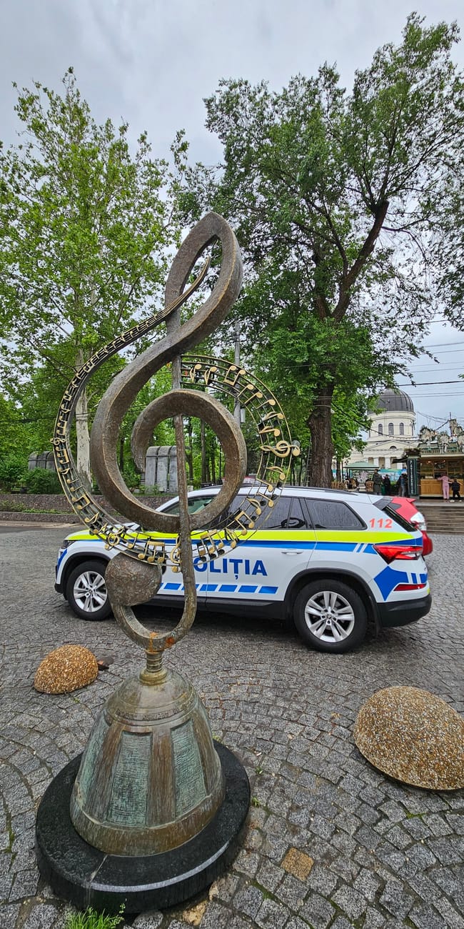 Rzeźba klucza wiolinowego na ulicy eugen doga w kiszyniowie, z policyjnym autem w tle