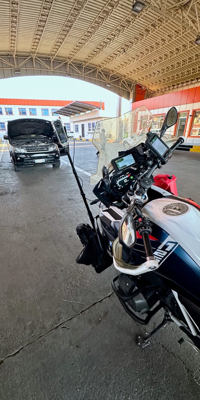 Motorcycle parked in iraq kurdistan border garage during desert horizons motorcycle expedition, with a vehicle ahead