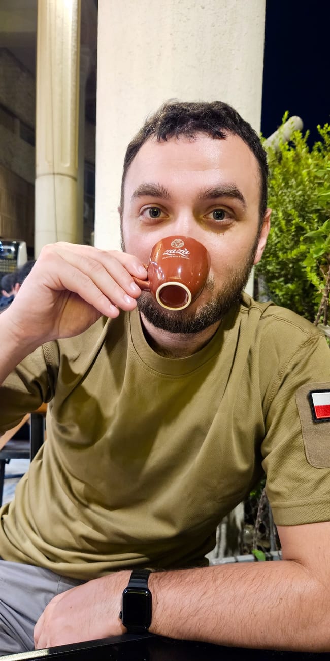 Mężczyzna pije kawę z małej filiżanki w ogródku kawiarni przy baghdad al rasheed street w iraku