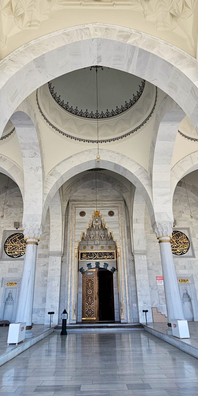 Interior view of turkey’s ankara melike hatun mosque with ornate arches, chandeliers, and a central minbar niche
