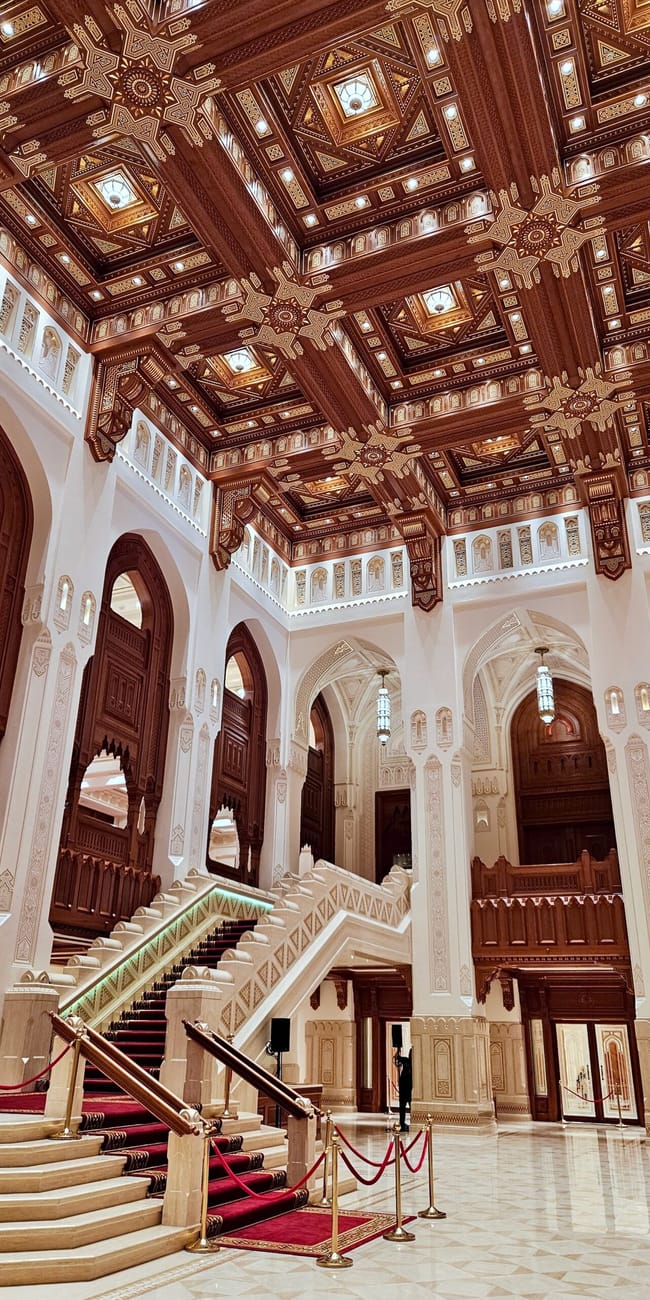 Wnętrze muscat royal opera house w omanie z bogato zdobionym drewnianym stropem i reprezentacyjnymi schodami