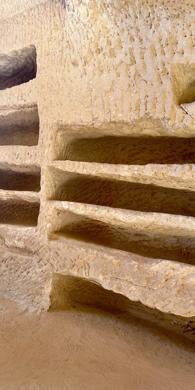 Al ula hegra, saudi arabia: carved sandstone niches in a weathered rock wall