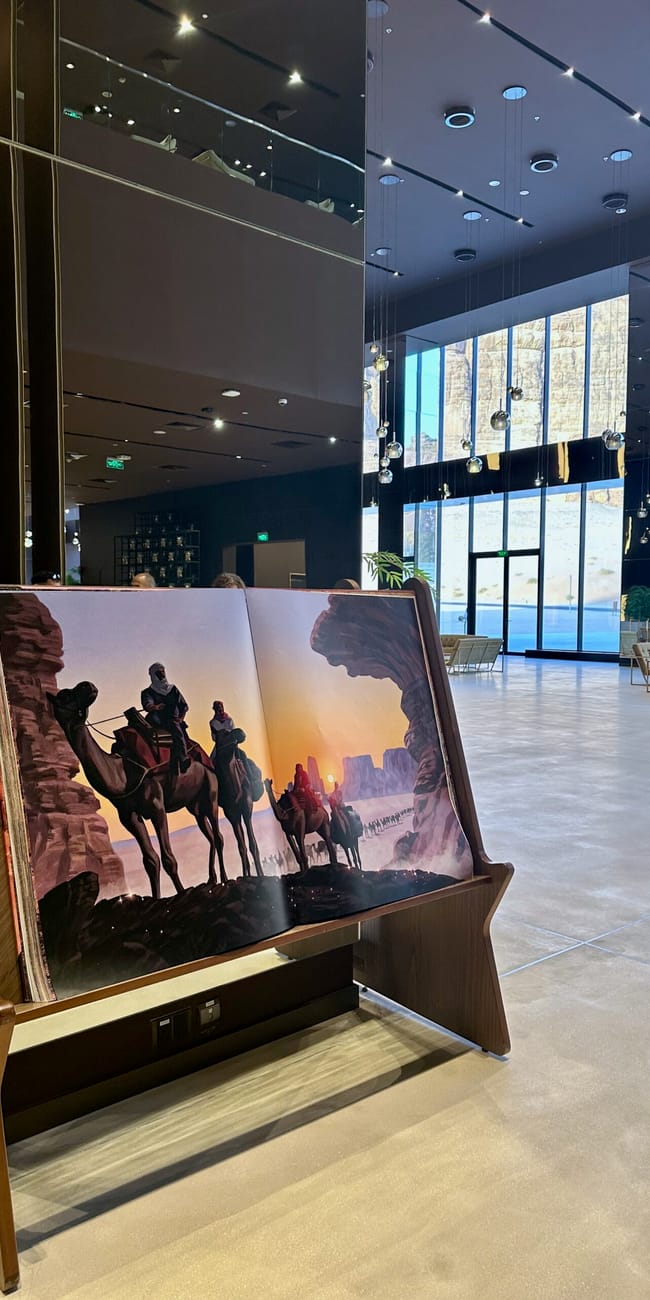 Saudi arabia, al ula maraya: a lobby seating area with a display mural and bright glass wall overlooking desert scenery