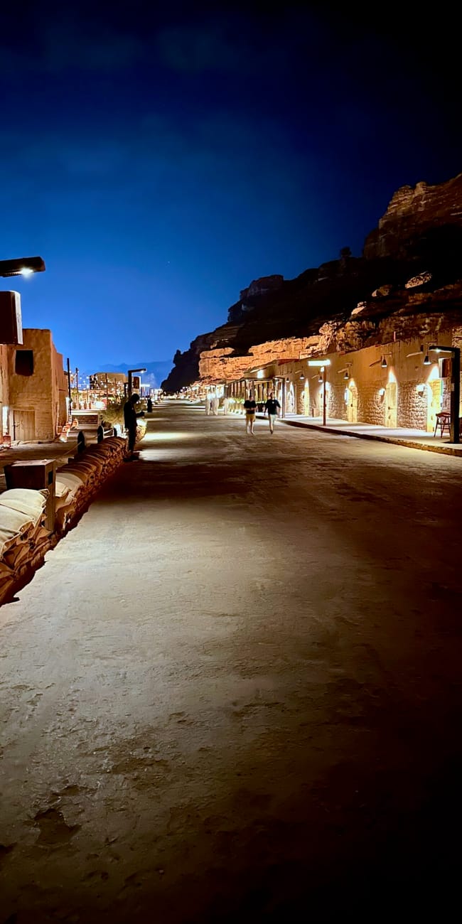Saudi arabia, al ula old town at night with lit stone buildings and a lantern-lit walkway.
