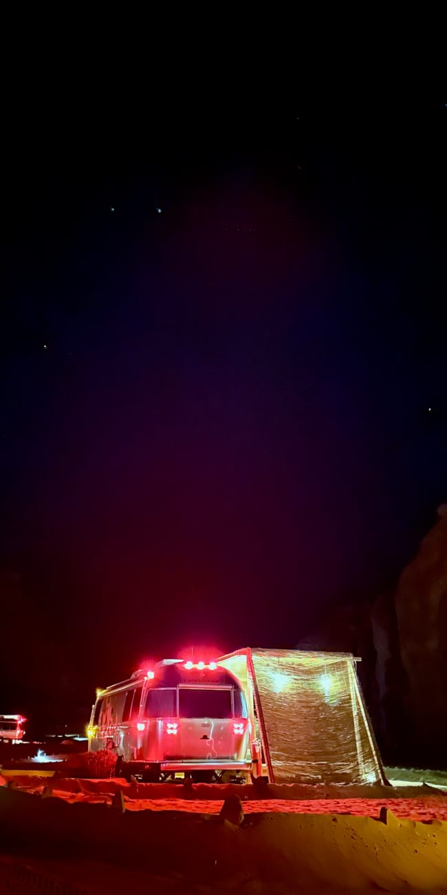 Night desert scene in al ula with a caravan truck and tents under a starry sky in saudi arabia