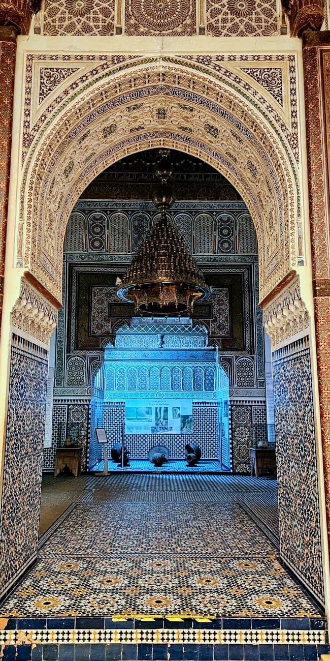 Marrakesz morocco museum interior with ornate arches, tiled walls, and a blue-lit display
