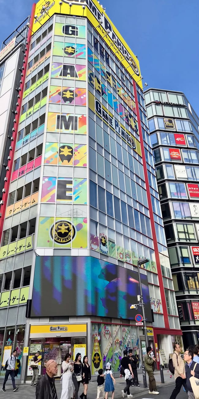 Akihabara w tokio z kolorowym budynkiem game panic i przechodniami na ulicy