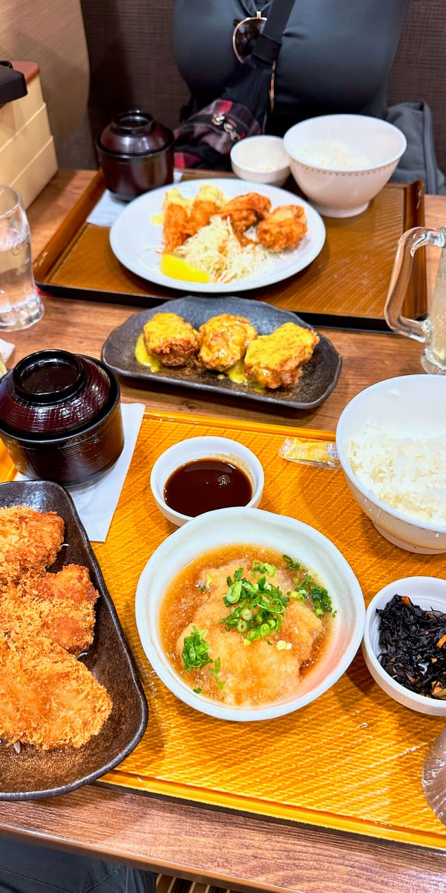 Jedzenie w restauracji w kioto: japońskie zestawy z panierowanym mięsem, ryżem i dodatkami