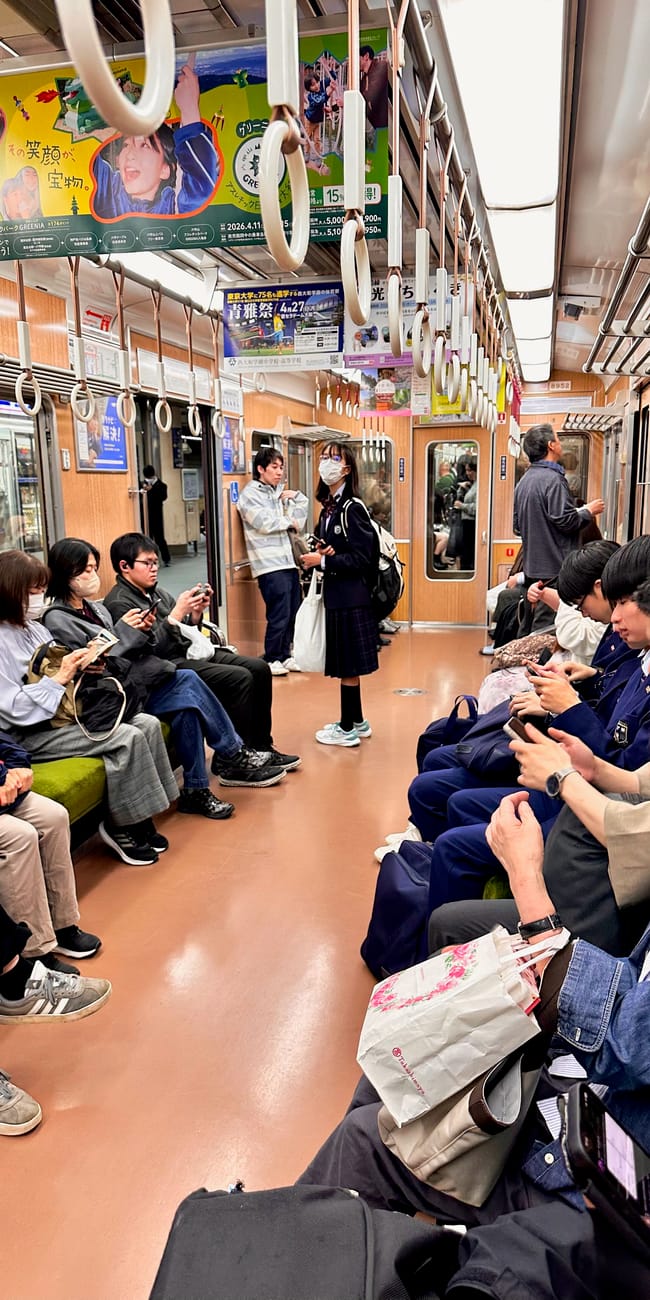 Wnętrze metra hankyu w kioto z pasażerami siedzącymi i stojącymi w wagonie