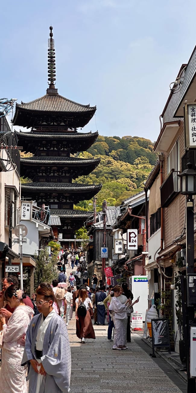 Widok na yasaka pagoda w kioto, z ulicą pełną spacerowiczów i sklepami po bokach