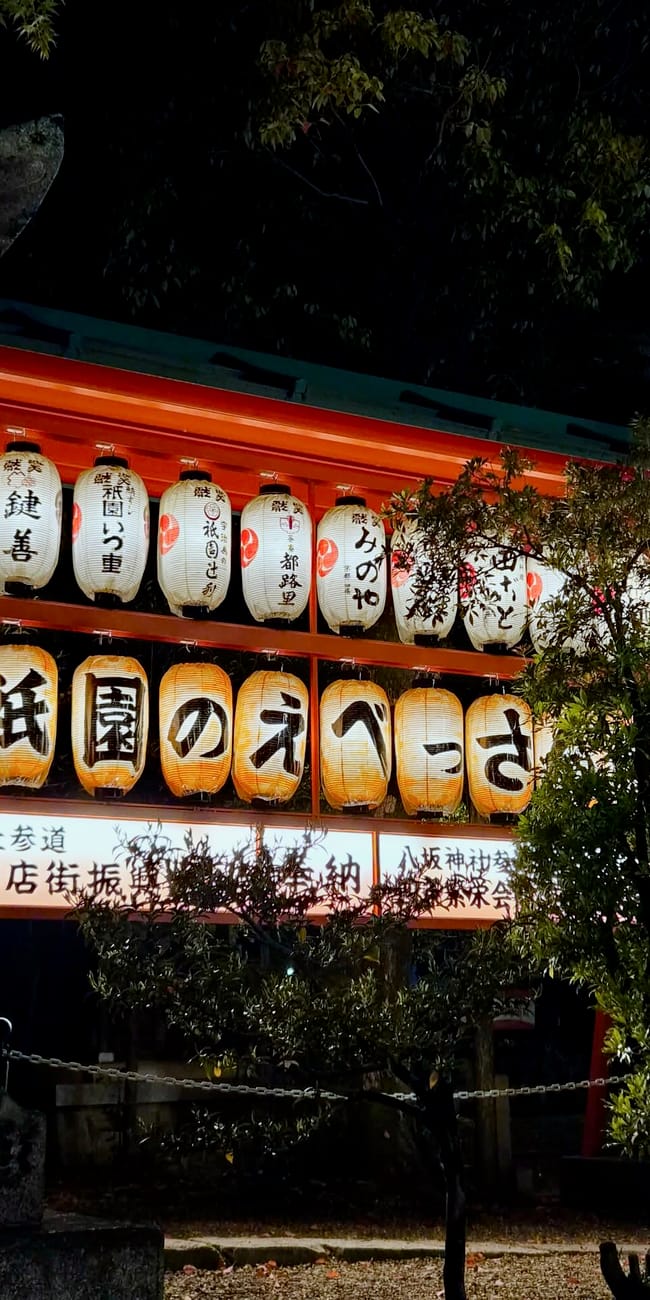 Yasaka shrine nocą w kioto, z rzędem podświetlonych lampionów przy wejściu