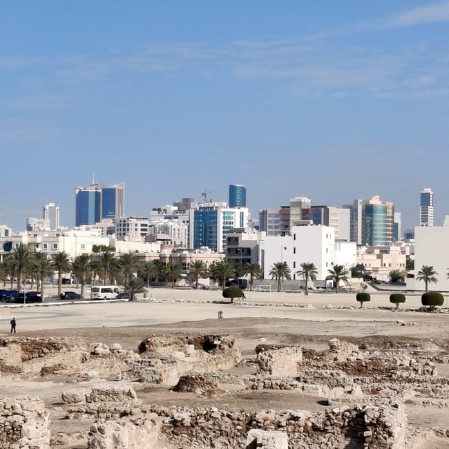 Ruiny bahrain fort na tle nowoczesnej panoramy manamy, bahrajn