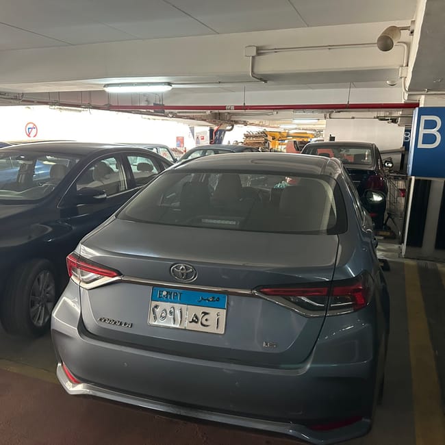 Car rental parking garage in egypt with a gray toyota corolla