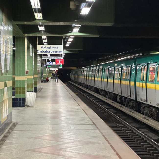 Cairo metro platform with a train and an imbaba direction sign