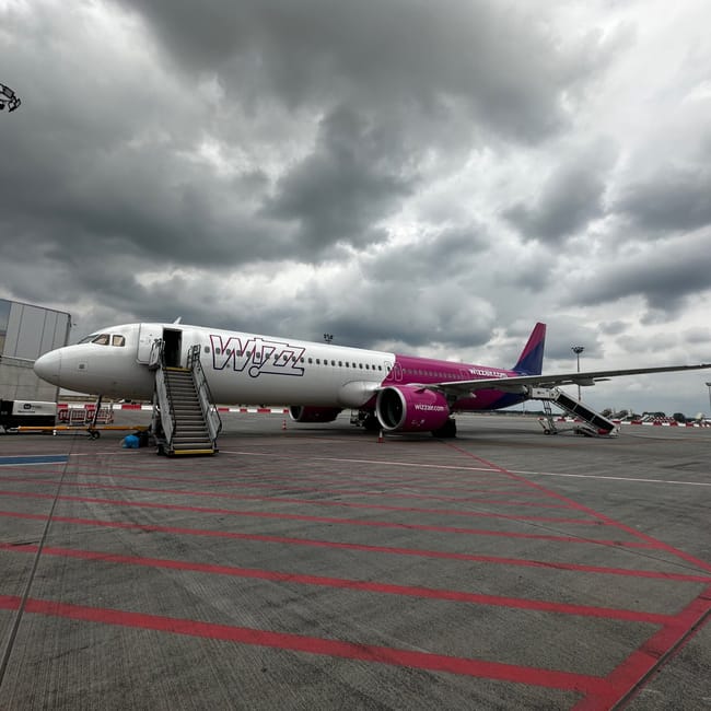 Samolot wizz air na płycie lotniska pod ciemnym, burzowym niebem w arabii saudyjskiej