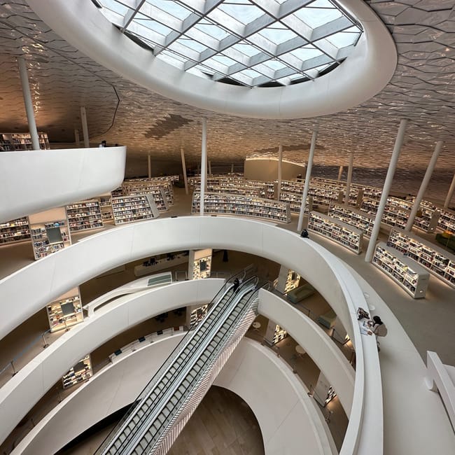 Wnętrze ithra w dammam z krętymi galeriami i regałami książek pod kopułą.