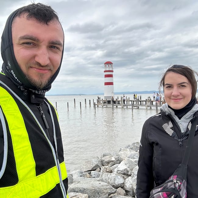 Para przy latarni podersdorf w austrii, nad jeziorem pod pochmurnym niebem
