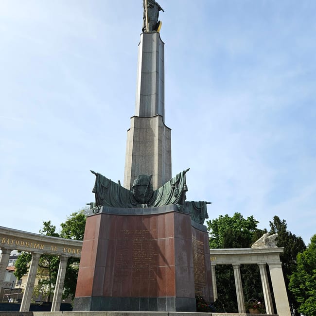 Vienna red army monument, wysoki pomnik z czerwoną podstawą i kolumnadą w tle, na tle nieba