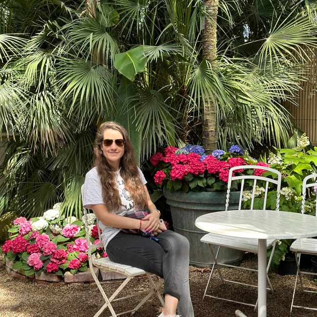 Vienna palm house w wiedniu, kobieta siedzi w ogrodzie otoczonym palmami i kolorowymi kwiatami