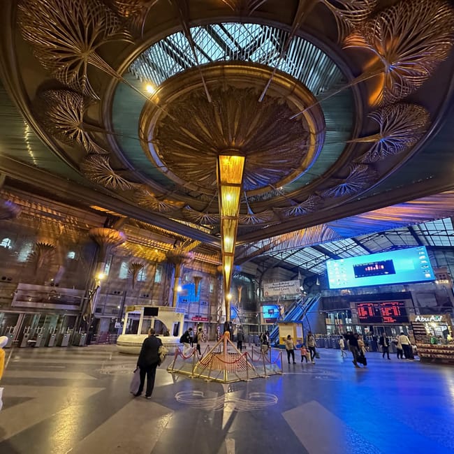 Hol dworca cairo ramsis station w kairze z ozdobnym sufitem i podróżnymi.
