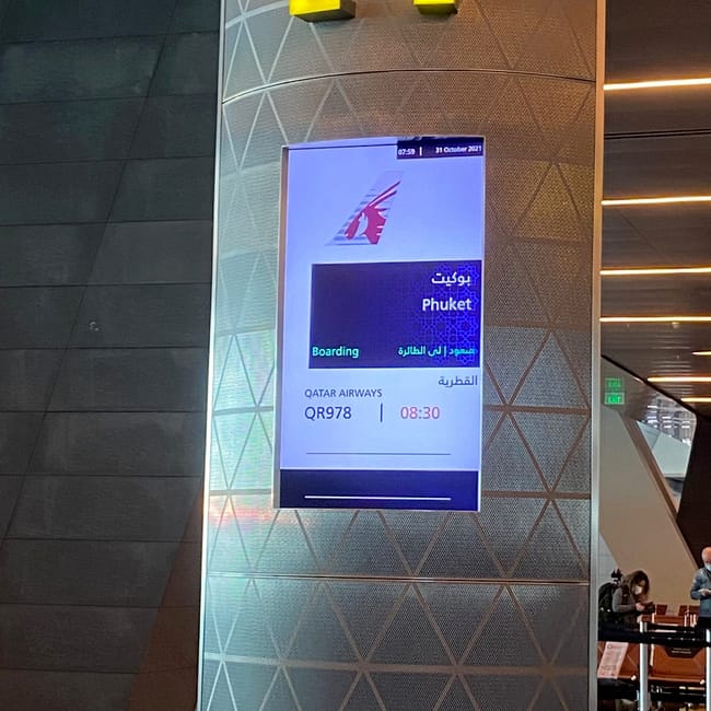 Tablica odlotów na lotnisku pokazuje boarding rejsu qatar airways do phuket.