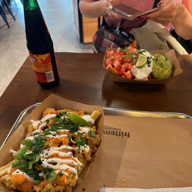 Berlin foods: dwa dania street food z sosem i zieleniną na stole w lokalu