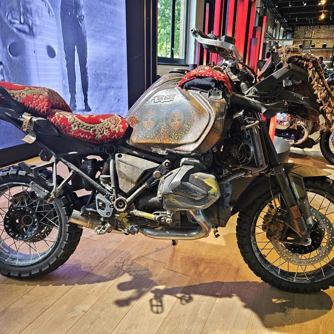Bmw motorrad werk w berlinie: stary motocykl bmw gs z ozdobnym, nietypowym wykończeniem na wystawie.