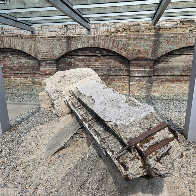 Berlin terror museum w berlinie: zniszczony betonowy blok z metalowymi prętami pod zadaszeniem.