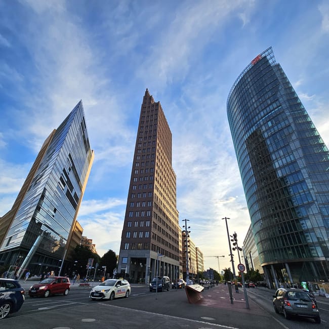 Berlin potsdamer platz z nowoczesnymi wieżowcami i ruchem ulicznym pod błękitnym niebem