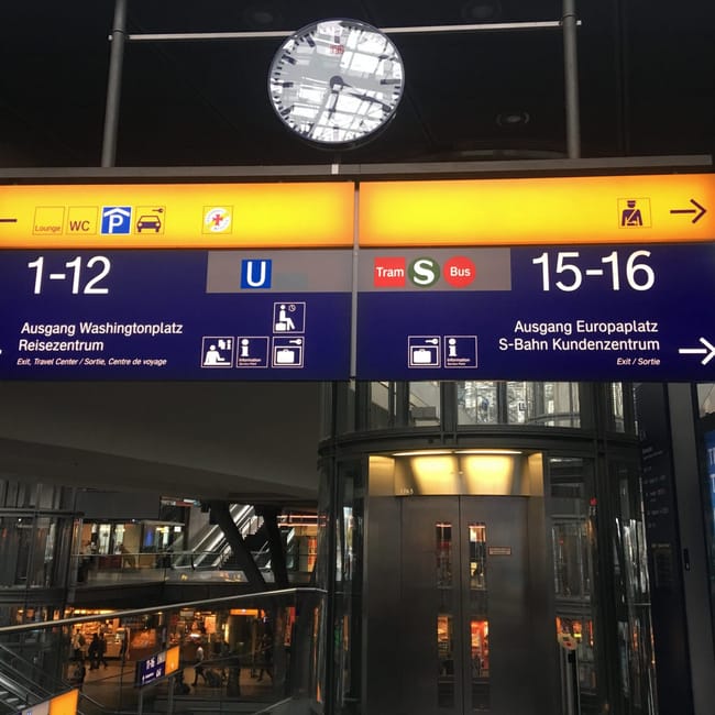 Berlin hauptbahnhof z dużymi znakami kierunkowymi i zegarem pod sufitem
