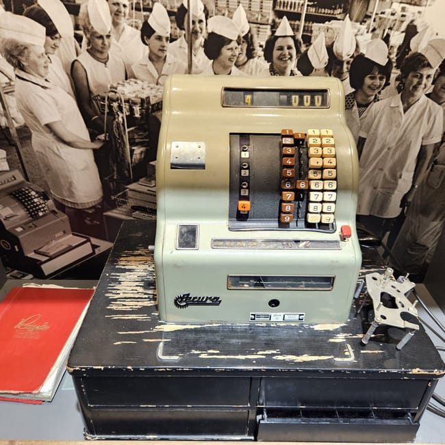 Kasa fiskalna w muzeum ddr w berlinie na tle zdjęcia pracownic sklepu