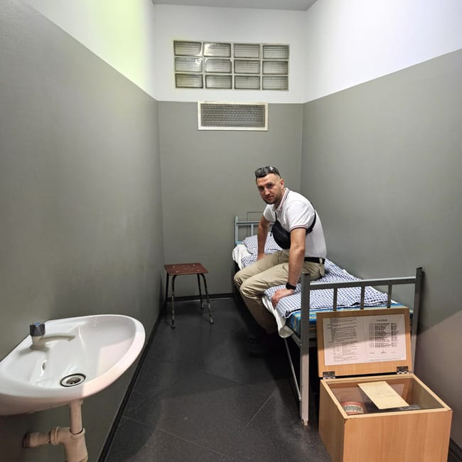 Ekspozycja w ddr museum w berlinie z celą więzienną i siedzącym na pryczy mężczyzną
