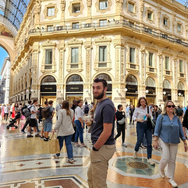 Galleria vittorio emanuele ii w mediolanie z tłumem turystów i osobą na pierwszym planie