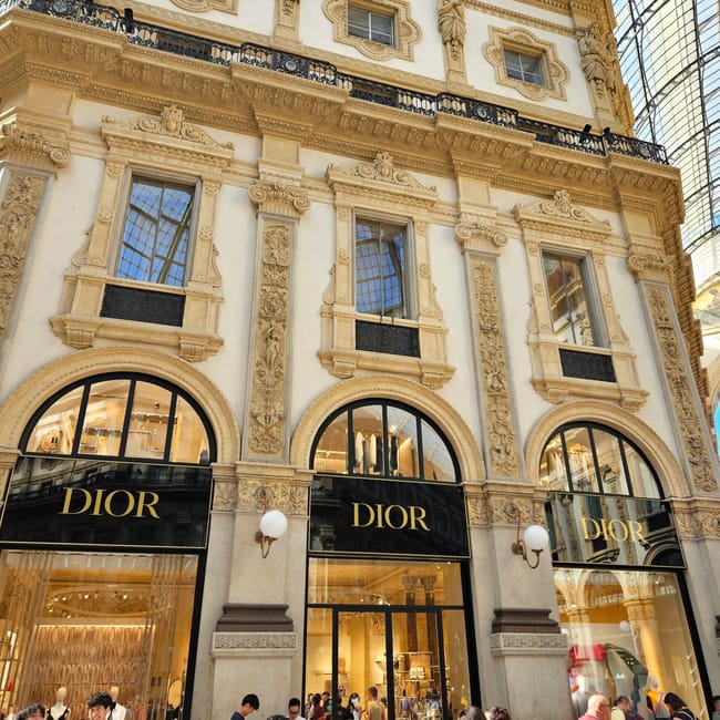 Sklep dior w galleria vittorio emanuele ii w mediolanie, z elegancką fasadą i przechodniami.
