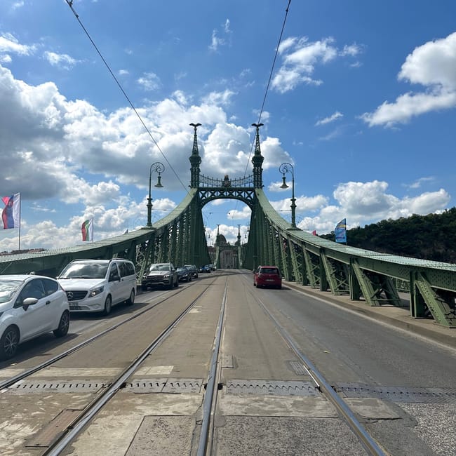 Most wolności w budapeszcie z torami tramwajowymi i samochodami pod błękitnym niebem