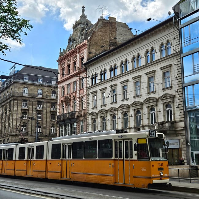 Żółty tramwaj linii 47 w centrum budapesztu przy historycznych kamienicach