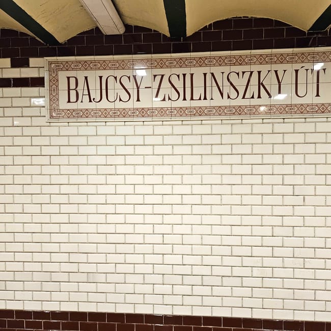 Tablica stacji metra bajcsy-zsilinszky út w budapeszcie na białej kafelkowej ścianie
