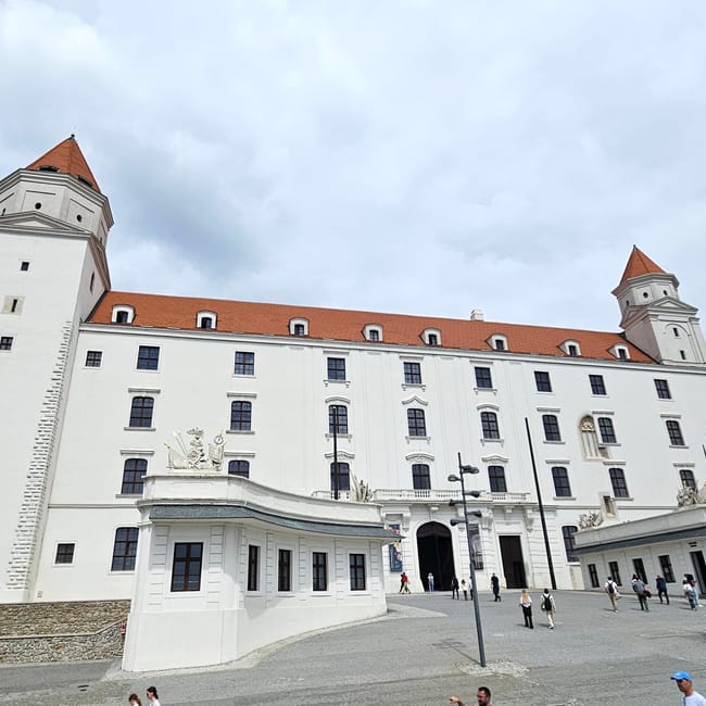 Bratysławski zamek na wzgórzu, biały budynek z czerwonym dachem i wieżami