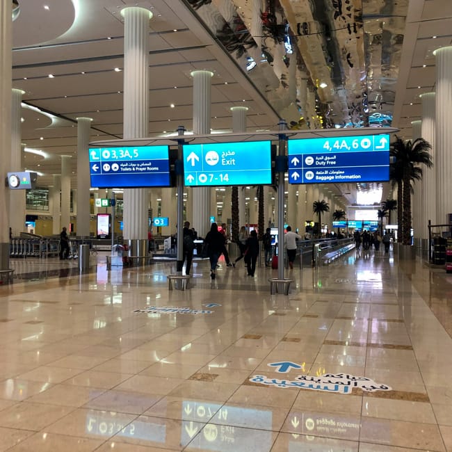 Hala odlotów na lotnisku w dubaju z oznaczeniami kierunku i pasażerami