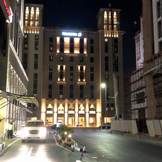 Nocny widok hotelu w dubaju z podświetloną fasadą i podjazdem dla samochodów