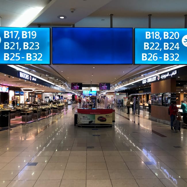 Dubai airport: korytarz handlowy z oznaczeniami bramek b17–b32 i sklepami duty free